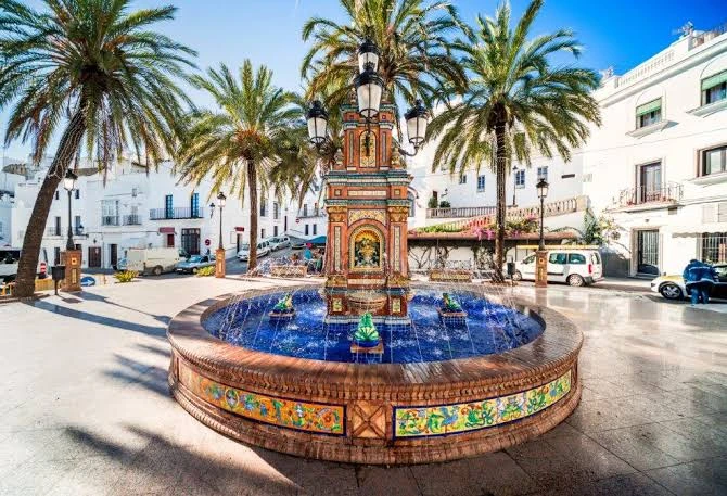 La fontaine en azulejos de la Plazuela, parmi les palmiers